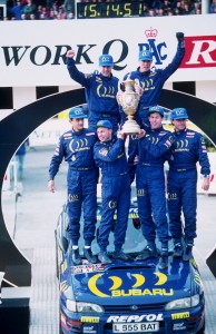 Subaru World Rally Team, Colin McRae and Derek Ringer (centre), flanked by Carlos Sainz (right) and Luis Moya (left) with Richard Burns and Robert Reid behind at the end of the 1995 Network Q Rally of Great Britain.